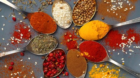 Spices background. Indian and Asian food spices on spoons and dark background. Curry, pepper, chili as ingredients of Indian cuisine
