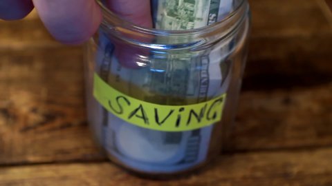 business concept.banking. glass jar with savings. paper hundred dollar bills lie in a moneybox.close-up.shallow depth of field.