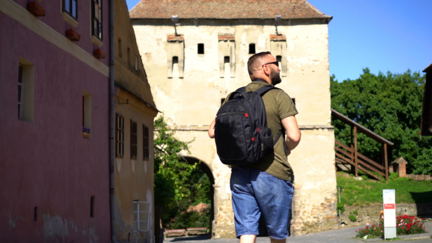 Young man admire, sightseeing old medieval city in Romania