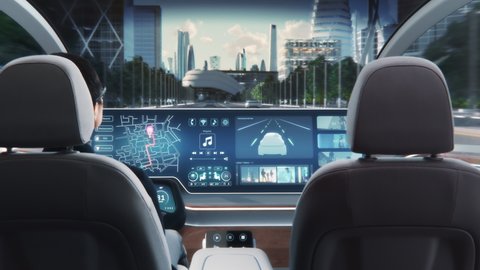Futuristic Concept: Stylish Businessman Setting Location on an Interactive Navigation App on an Augmented Reality Dashboard while Sitting in an Autonomous Self-Driving Zero-Emissions Electric Car. 