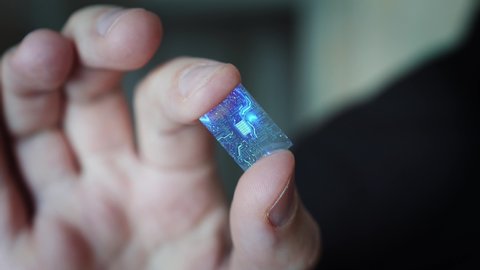 Close Up Macro Zoom Shot a Man Holds a Computer Processor With Holographic Luminous Chip Elements.
