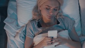 top view of woman putting away smartphone, turning off light and going to sleep