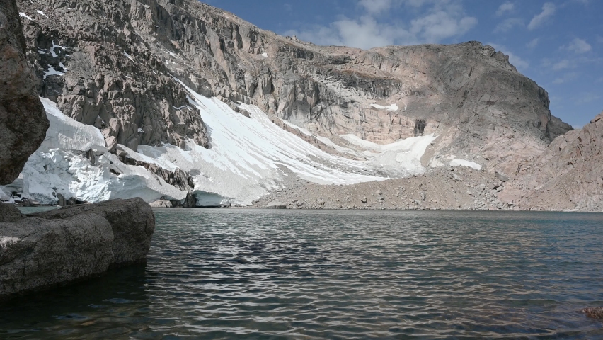A remote destination featuring a high elevation lake and melting glacier in Rocky Mountain National Park, Colorado, USA, summer time