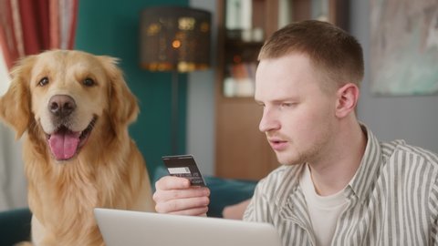 Man purchase online delivery with his retriever dog, e-commerce shopping for pets, food and toys gift for small animal friends, redhead british student and his puppy make payment with credit card