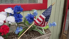 Slow pan, Red white, and blue carnations, and a small American flag, rustic flowerbox - Powered by Shutterstock - Get 15% off with code: PIKWIZARD15