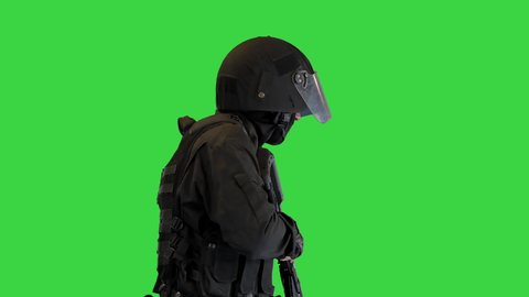 Police anti terrorism squad fighter shooting from rifle on a Green Screen, Chroma Key.