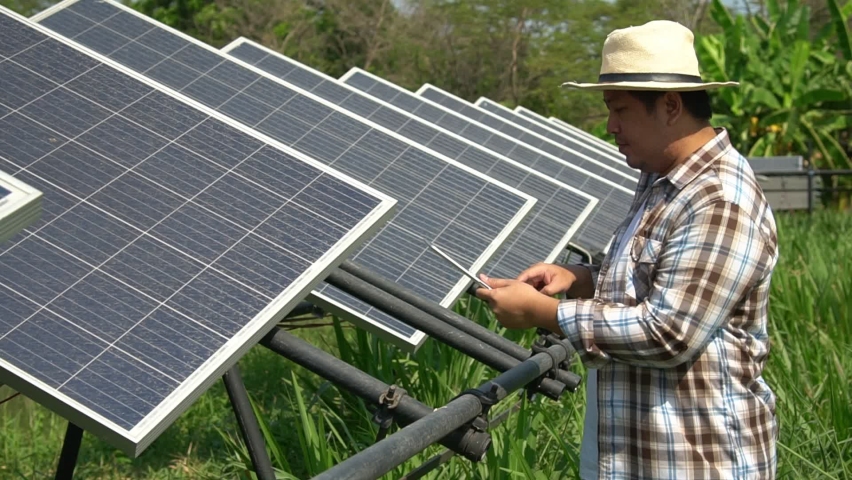Asian farmers use tablets to adjust solar cells degree and check solar cell performance after rain and Dust and dirt stains on the solar cell. Concept of farming technology. Royalty-Free Stock Footage #1067484152
