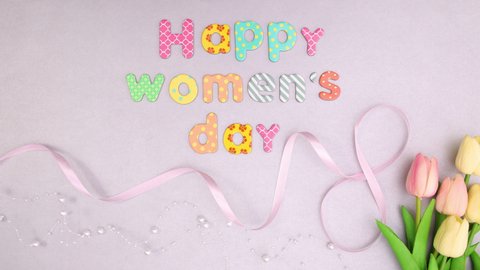 Happy women's day text move with flowers and ribbons. Stop motion