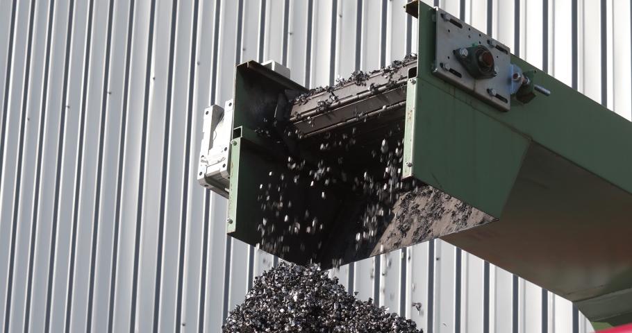 Metal pieces falling into a box from recycling processing machine. Recycled scrap metal in stock. Metal shavings production waste Royalty-Free Stock Footage #1067498021