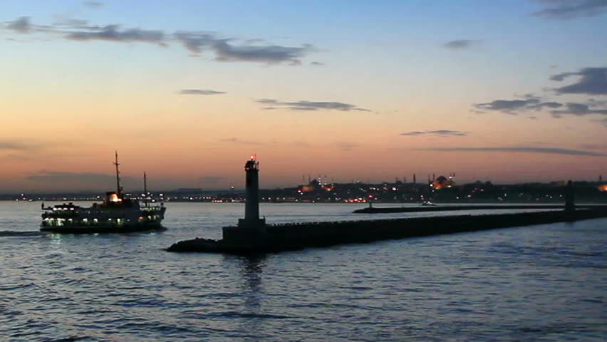Ferry and tug boat leaves from Kadikoy harbor at sundown