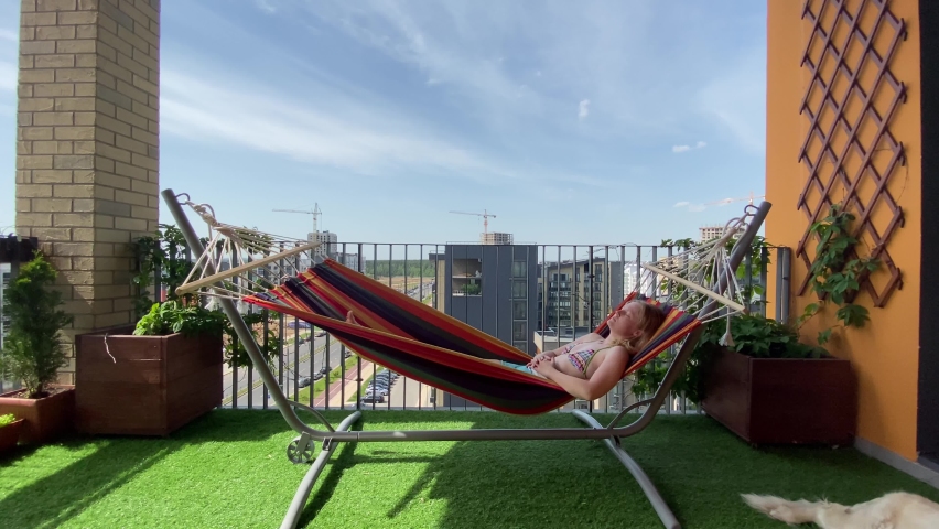 rest in the city. woman in bikini relax on hammock on terrace Royalty-Free Stock Footage #1067501561