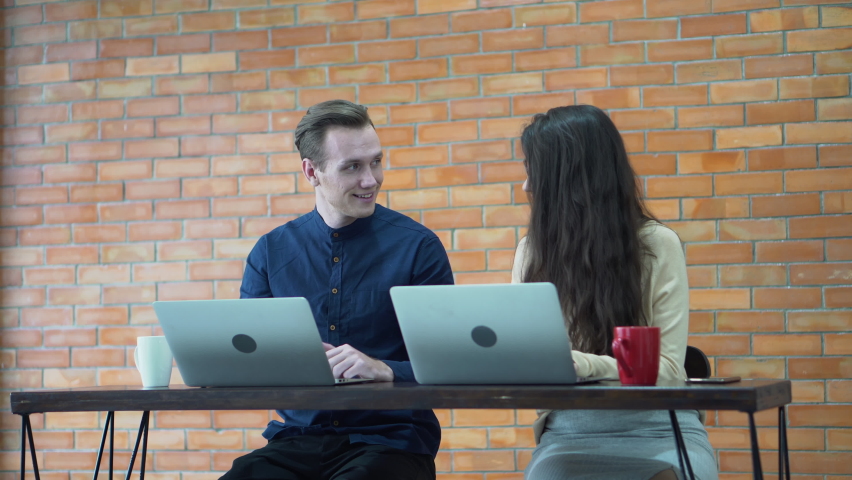 businessman and businesswoman  using laptop computer and talking   together in coffee shop or modern  office 