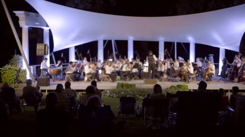 Evening Panning Shot of People Enjoying an Outdoor Orchestra Summer Concert