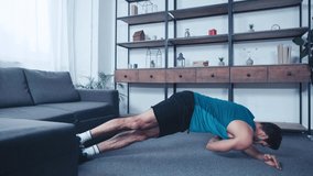 young sportsman training in side plank pose of floor at home