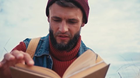 Low angle view of man reading book outside
