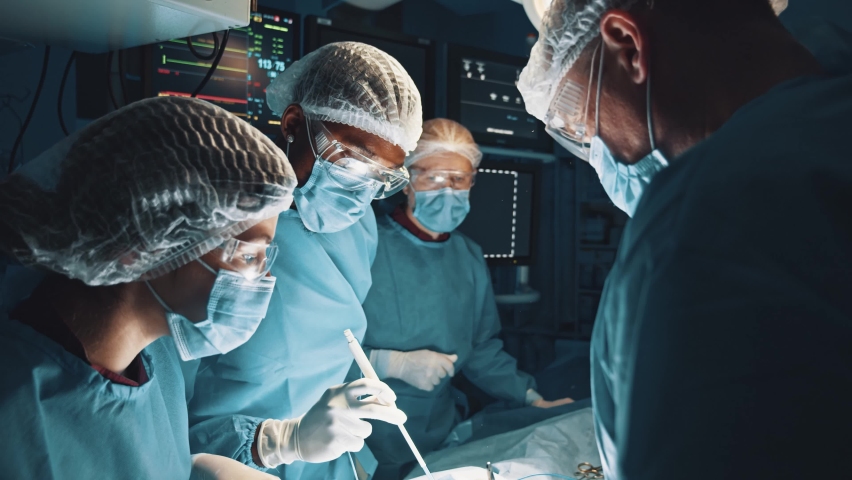 Experts in saving lives. Team of professional surgeons working at the hospital performing surgical procedure in operating theatre over a patient under anesthesia. Profession job career and experience Royalty-Free Stock Footage #1067519378