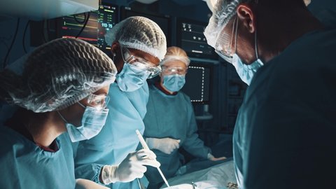 Experts in saving lives. Team of professional surgeons working at the hospital performing surgical procedure in operating theatre over a patient under anesthesia. Profession job career and experience