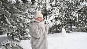 Beautiful young european woman on a walk in a snowy forest - video portrait
