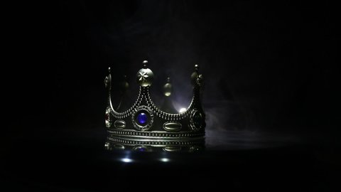 Beautiful king crown over metallic surface. vintage filtered. fantasy medieval period. Selective focus. Colorful backlight