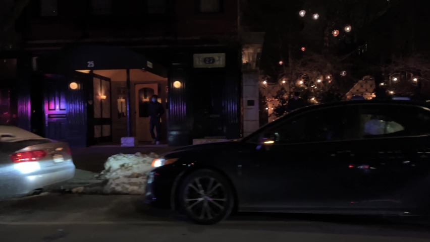 NYC, USA - FEB 12, 2021: NYPD traffic police towing cars illegally parked outside nightlife bars and clubs winter snow East Village Manhattan New York City.
