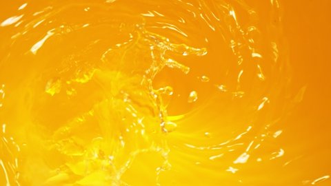 Super Slow Motion Shot of Pouring Fresh Orange Juice into Whirl at 1000 fps.