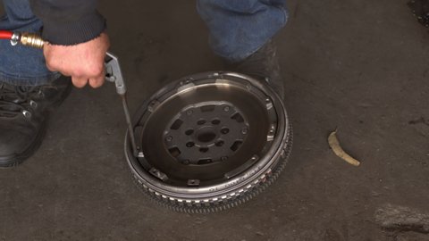 Master In Auto Repair Shop Cleans Old Flywheel Gear With Air Compressor