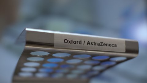 London , United Kingdom (UK) - 12 09 2020: Coronavirus Oxford AstraZeneca Vaccine Test Tube Vials Being Placed Into Rack. Locked Off, Low Angle, Close Up