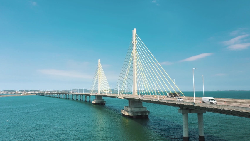 Establishing shot of traffic on beautiful bridge above the ocean