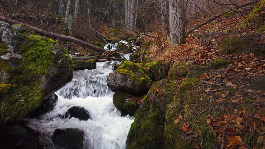 Waterfall on Falls creek flowing between moss covered boulders in Chugach state park in late autumn near Anchorage Alaska.