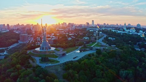Aerial view to the Motherland statue in the Kiev while a beautiful summer sunset. Ukraine. 2020 year. Monument of the Motherland in Kiev. Flying a drone around famous monument in Ukraine Motherland. 