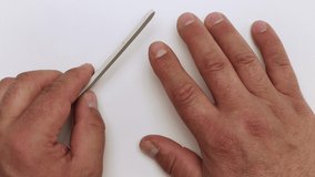 A plastic nail file gently treats the index finger in close-up. The master teaches and shows the techniques of work. Professional care, DIY manicure. Isolated video on a white background.