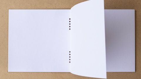 4k-Stop motion book animation open white blank page for writing on wooden background.