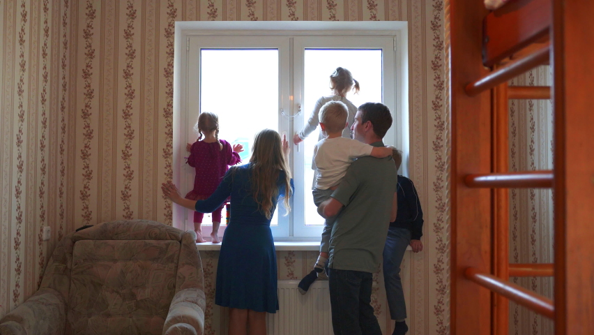 Large and friendly family at the window during quarantine.