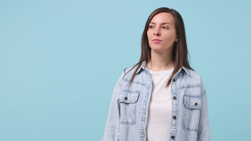 Surprised shocked excited fun young woman 30s years old in denim jacket white t-shirt point index finger aside scream in megaphone announces discounts sale Hurry up isolated on pastel blue background Royalty-Free Stock Footage #1067598722