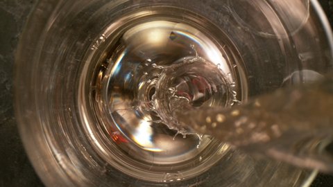 Camera Movement, Super Slow Motion Detail Shot of Pouring White Wine from Bottle with Black Stone Background at 1000fps.