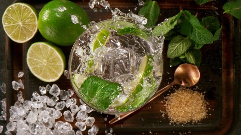 Camera Follows Ice cubes Falling into Glass of Fresh Mojito Cocktail. Super Slow Motion filmed on High Speed Cinema Camera.