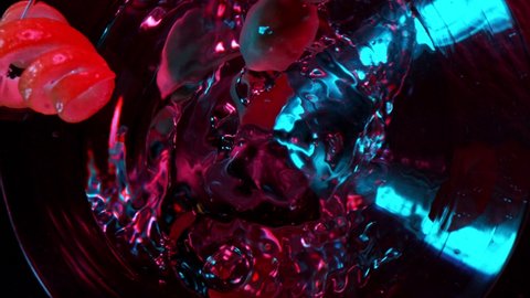 Camera Motion. Bright Cocktail with Falling Olives on Dark Background. Super Slow Motion.