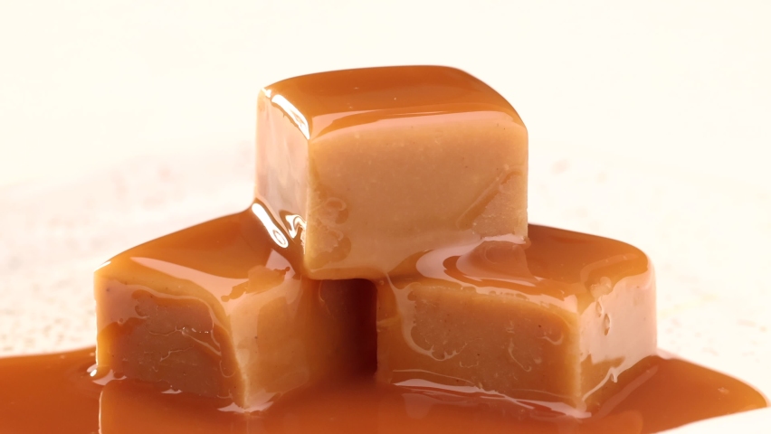 melted caramel sauce flowing on caramel candies close up Royalty-Free Stock Footage #1067611550