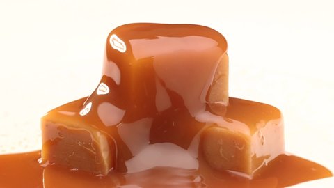 melted caramel sauce flowing on caramel candies close up