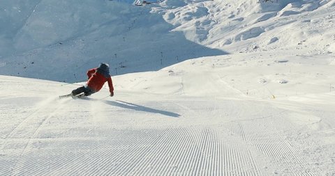 Professional Skiracer skiing fast turns on a ski slope. Sporty skiing on a nice ski slope in switzerland. Follow cam skiing with a athlethe. Skiing, Alps, Skiracing, Skislope.