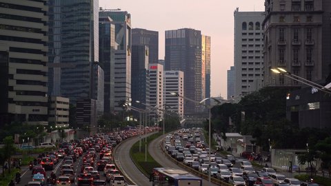 Jakarta, Indonesia - February 16 2021: A Transjakarta bus uses its busway while traffic is stuck in traffic jam on the Sudirman street in Jakarta business district in Indonesia capital city