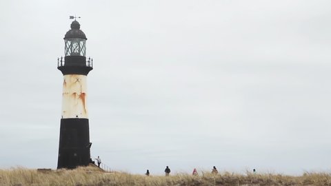People walking towards the Cape Pembroke Lighthouse, Falkland Islands (Islas Malvinas).  