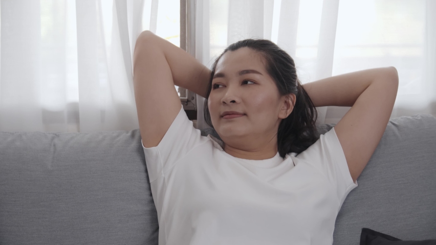 Happy Asian young female sitting and sleep on sofa for relax time at home | Shutterstock HD Video #1067619476