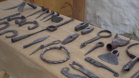 Historical medieval metal objects on the blacksmith shop. Medieval blacksmith's tools,hammers and iron tongs. Iron utensils, horseshoes, weapons