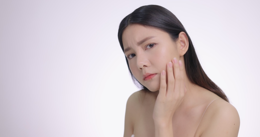 Beautiful Young Asian Woman Touching Her Face Softly. Feeling Worry About Face Skin Care Problem On Cheek. | Shutterstock HD Video #1067626181