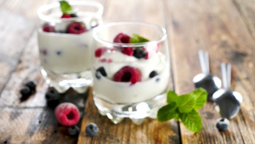 Yogurt and fresh fruits on wood background | Shutterstock HD Video #1067629964