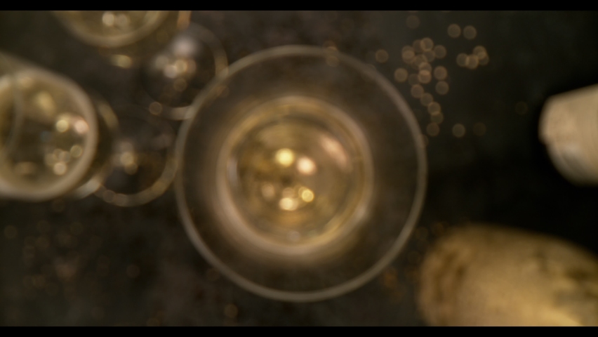 Camera Underwater Movement, Super Slow Motion Detail Shot of Pouring Champagne from Bottle on Black Stone Background 