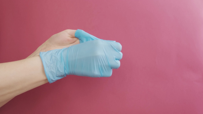 Young woman takes off medical gloves. Close-up. Concept of means of protection against infection with coronavirus infection, COVID-19
 | Shutterstock HD Video #1067636924