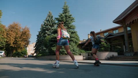 Young teenage girls rollerblading in a city park on a sunny summer day
