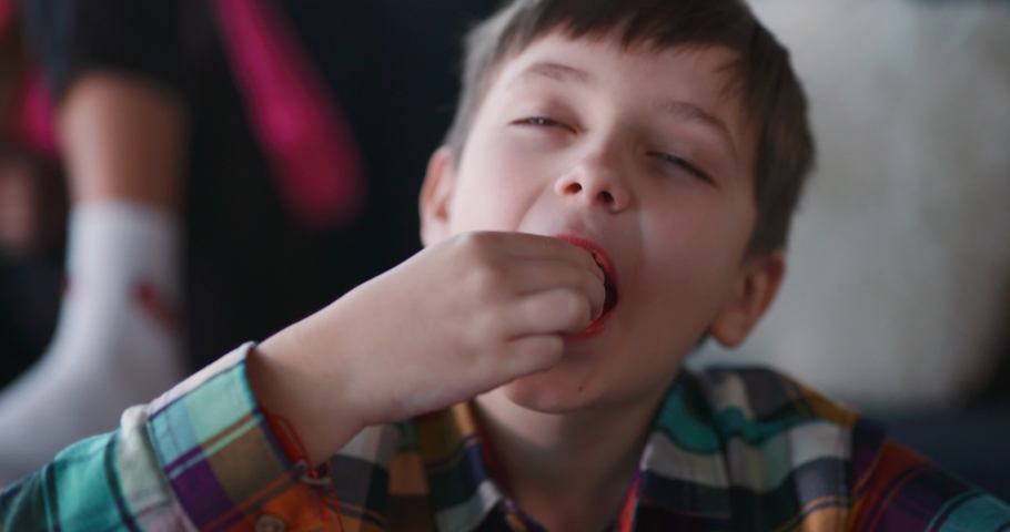 Close-up portrait of cute child boy eating a tasty candie closing eyes in satifaction enjoying leisure activity. Sugar addiction concept. Royalty-Free Stock Footage #1067663621